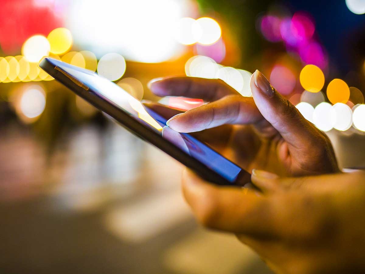 イルミネーションの中でスマートフォンを操作する人