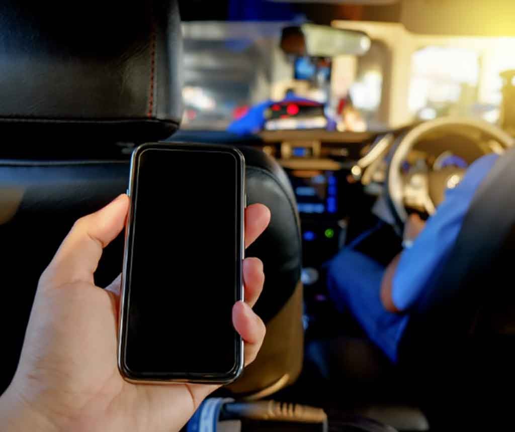 後部座席でスマートフォンを操作する男性