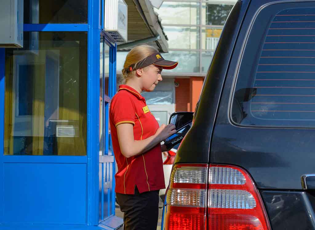 ドライブスルーの接客対応をするファストフード店員
