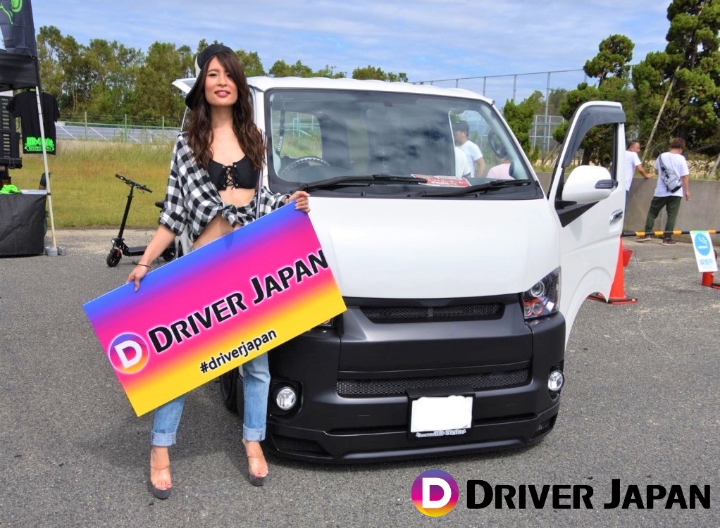 スーパーカーニバル2018参加ブースのハイエースの隣に立つ智花ちゃん