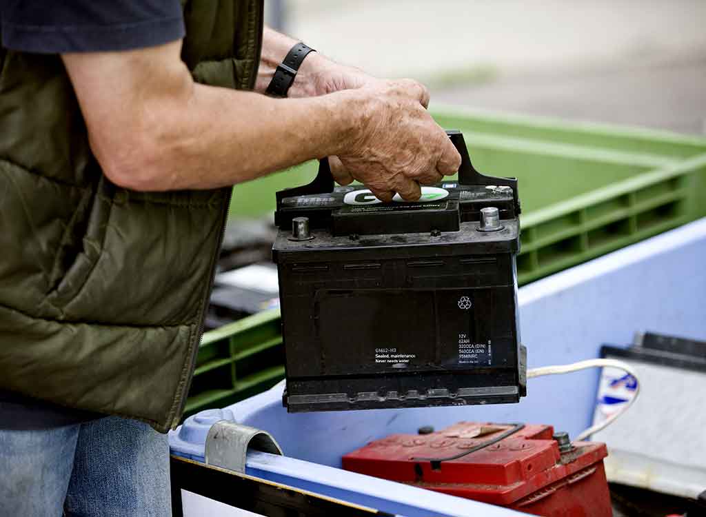 車のバッテリーを捨てる男性