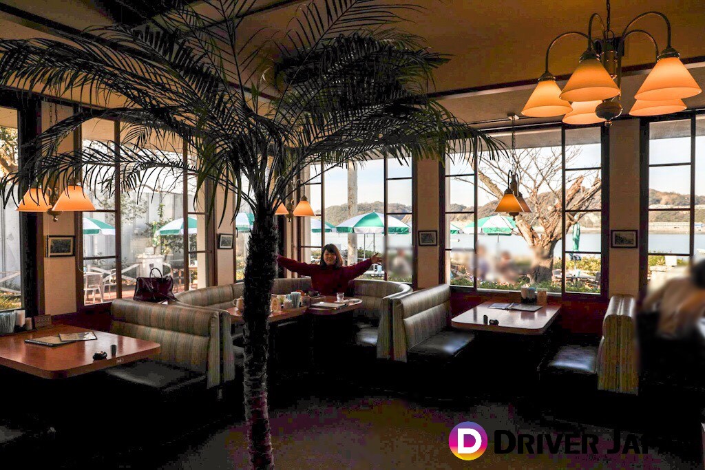 なぎさ橋珈琲　店内の様子　ソファー席で手を広げるあっこ