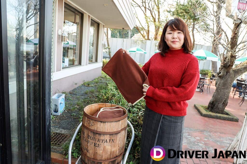 なぎさ橋珈琲 テラス席のひざ掛けを持っているあっこ