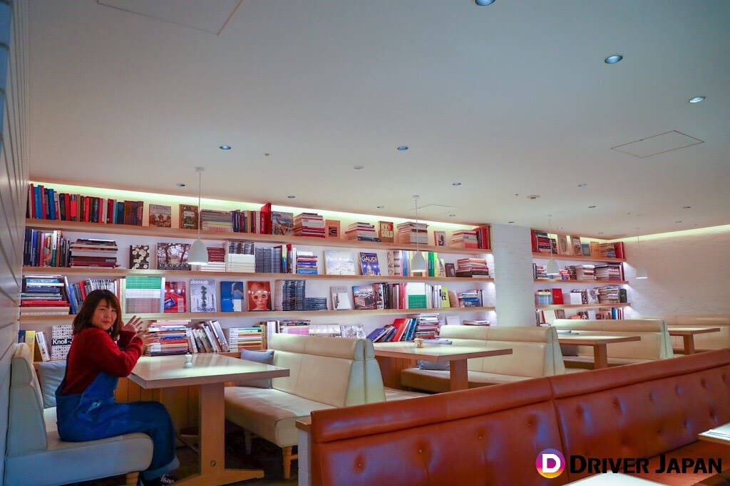 billsの内装　本棚に囲まれている席に座るあっこ