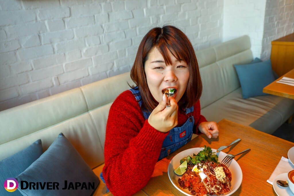 billsのおすすめモーニング　ソフトシェルクラブ・チョリソー・キムチのフライドライス/ポーチドエッグを食べるあっこ