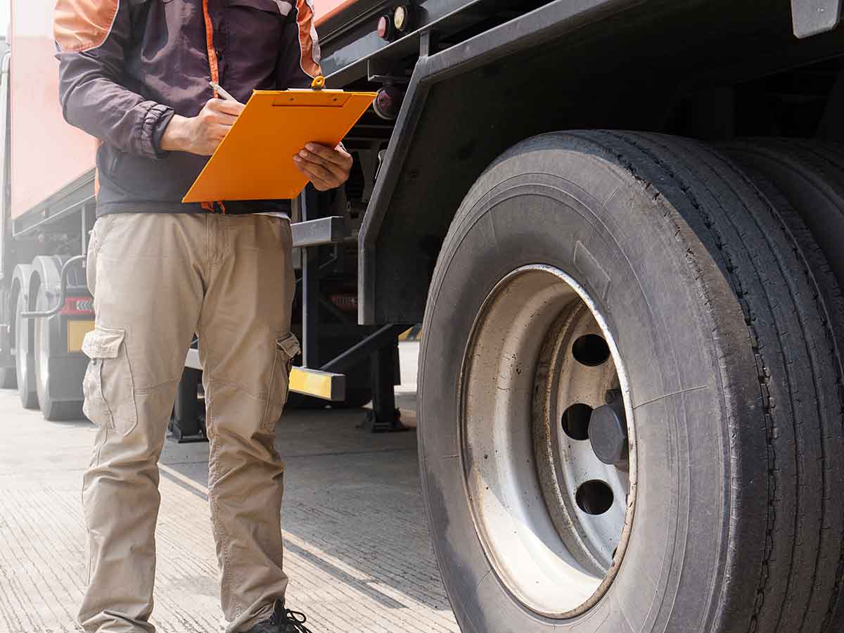 トラックのタイヤをチェックする男性