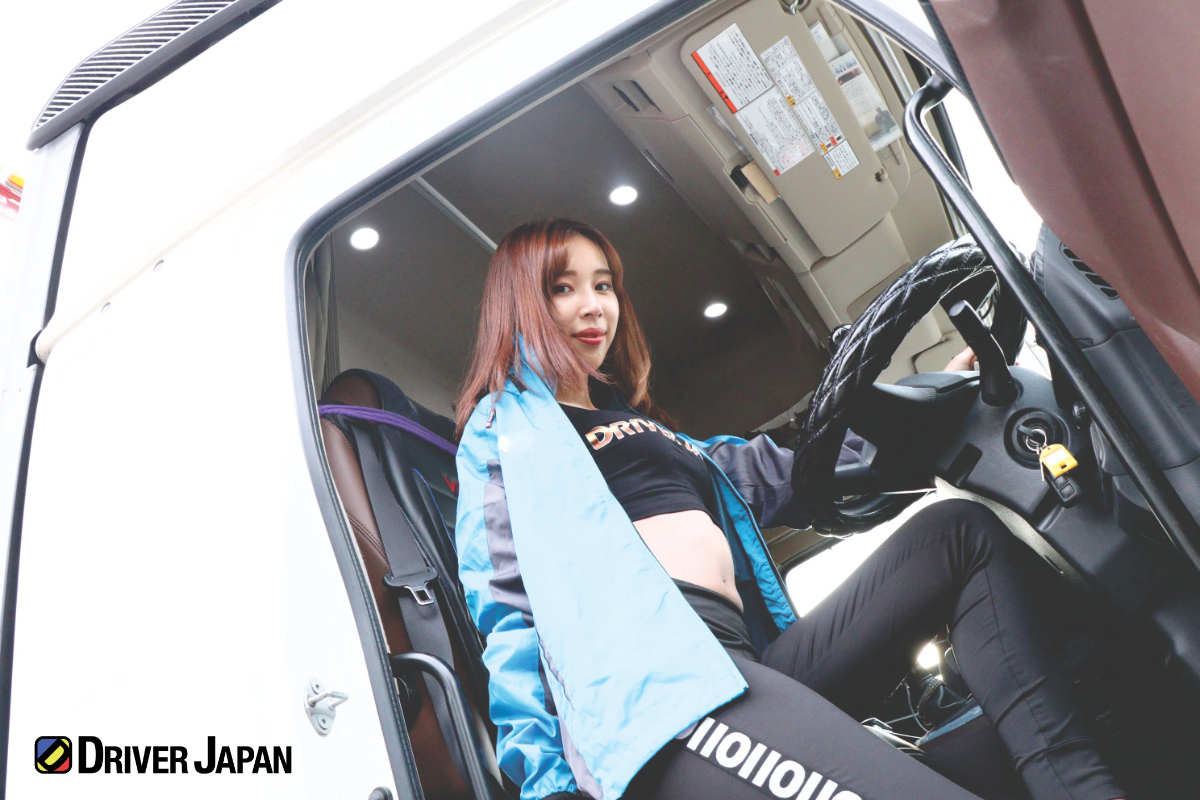 HINO PROFIA(日野プロフィア)の運転席に座るドライバージャパンガールズのAZUSA 株式会社友動運輸敷地内